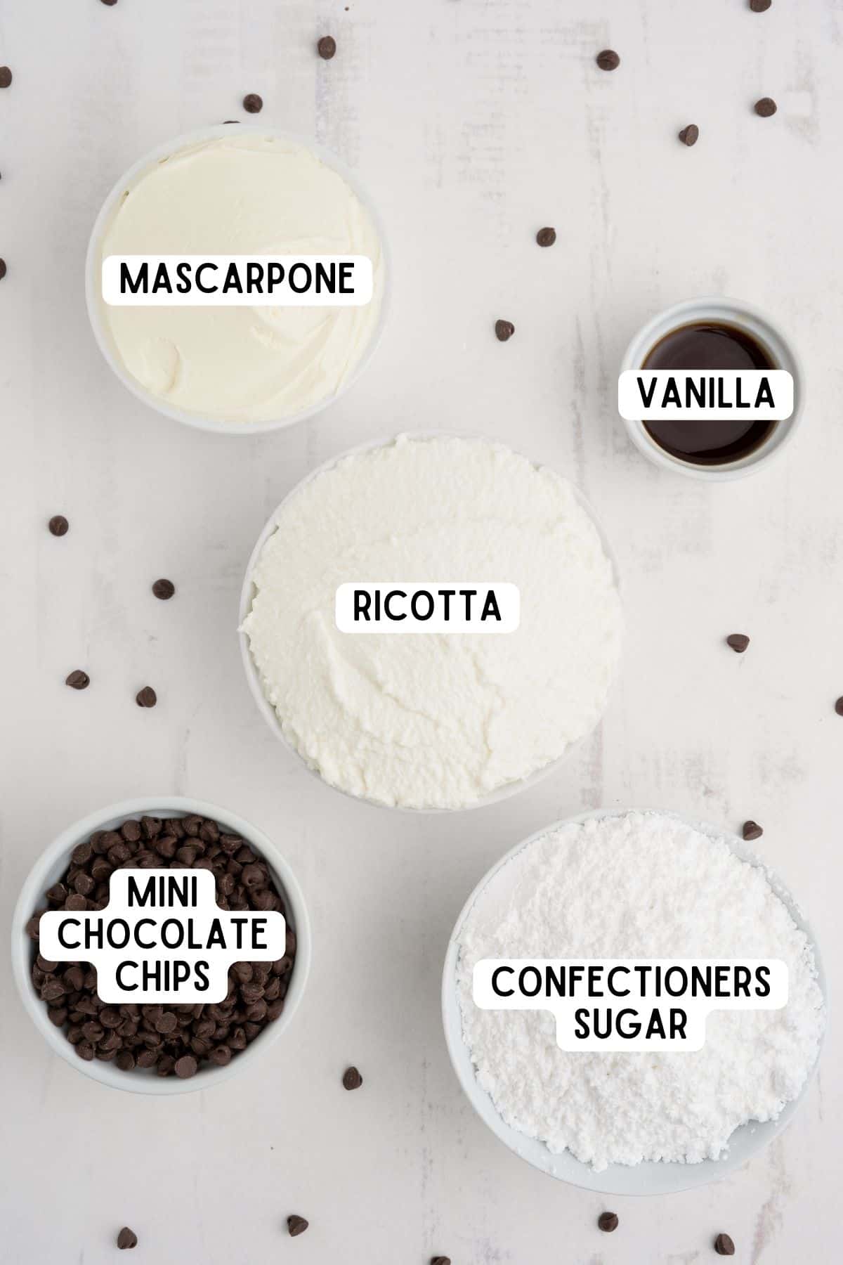 Mascarpone, ricotta, vanilla, mini chocolate chips, and confectioner's sugar in bowls.