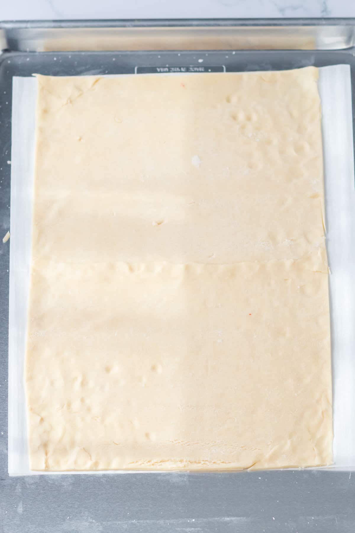 Rectangular pie crust on parchment lined baking sheet.