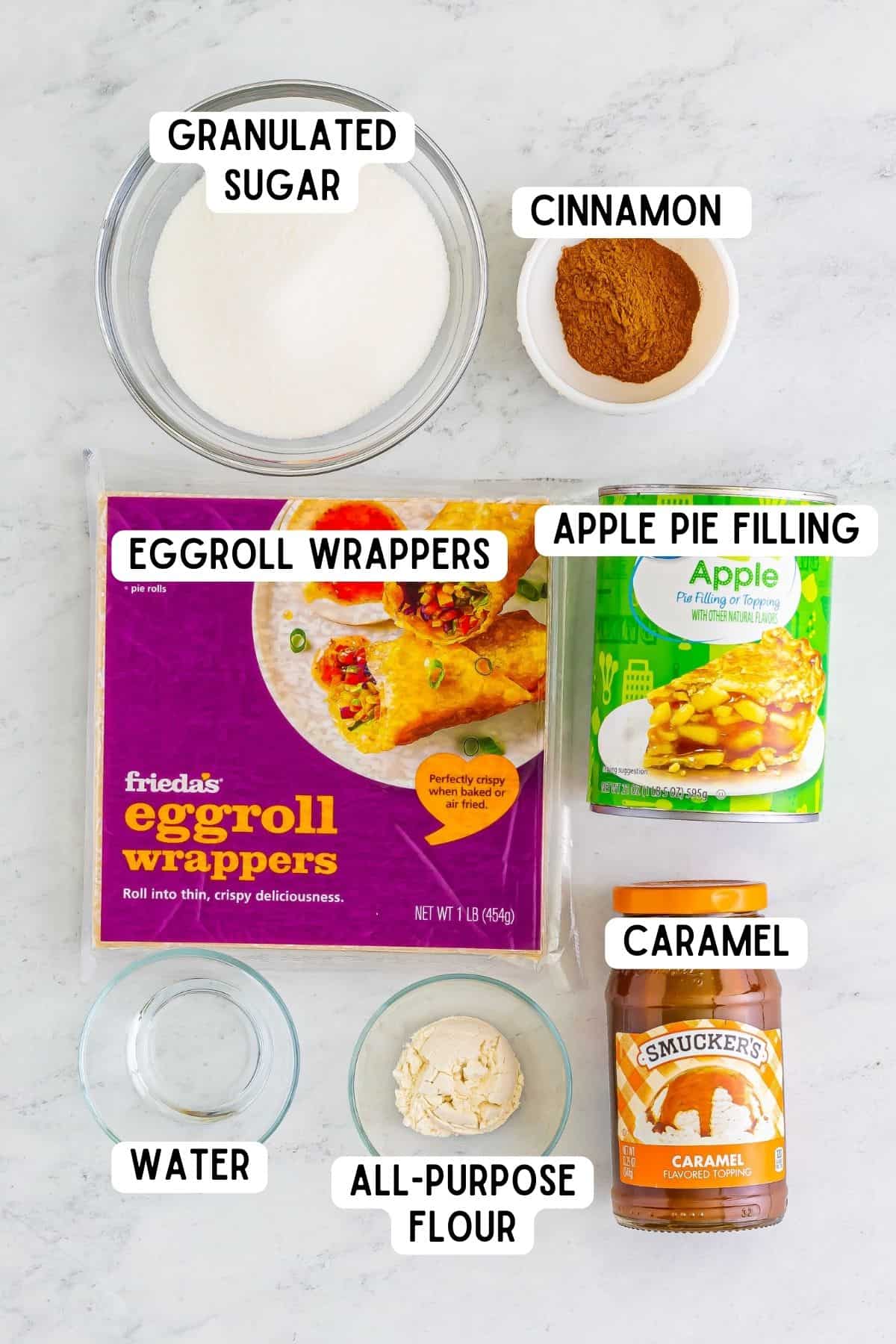 granulated sugar, ground cinnamon, water, flour, package of egg roll wrappers, can of apple pie filling, and jar of caramel.