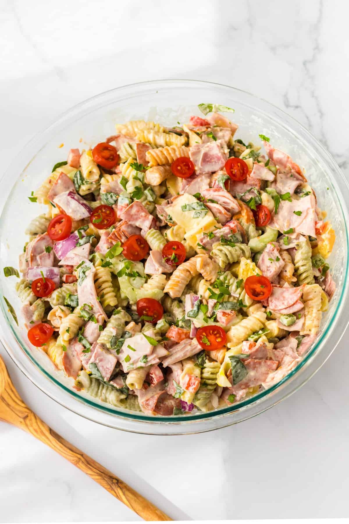 Coat meat pasta salad in glass bowl.