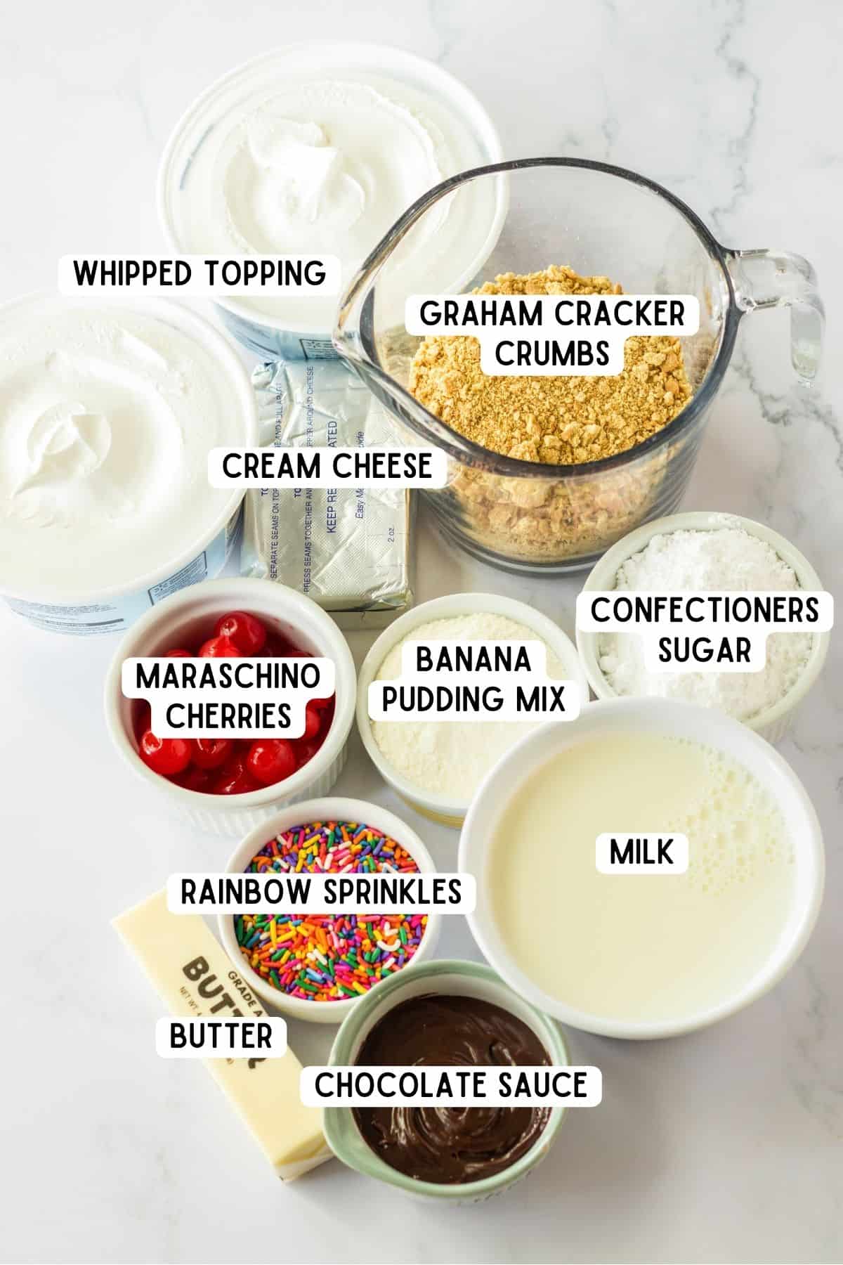 Ingredients for banana split dessert in bowls on countertop.