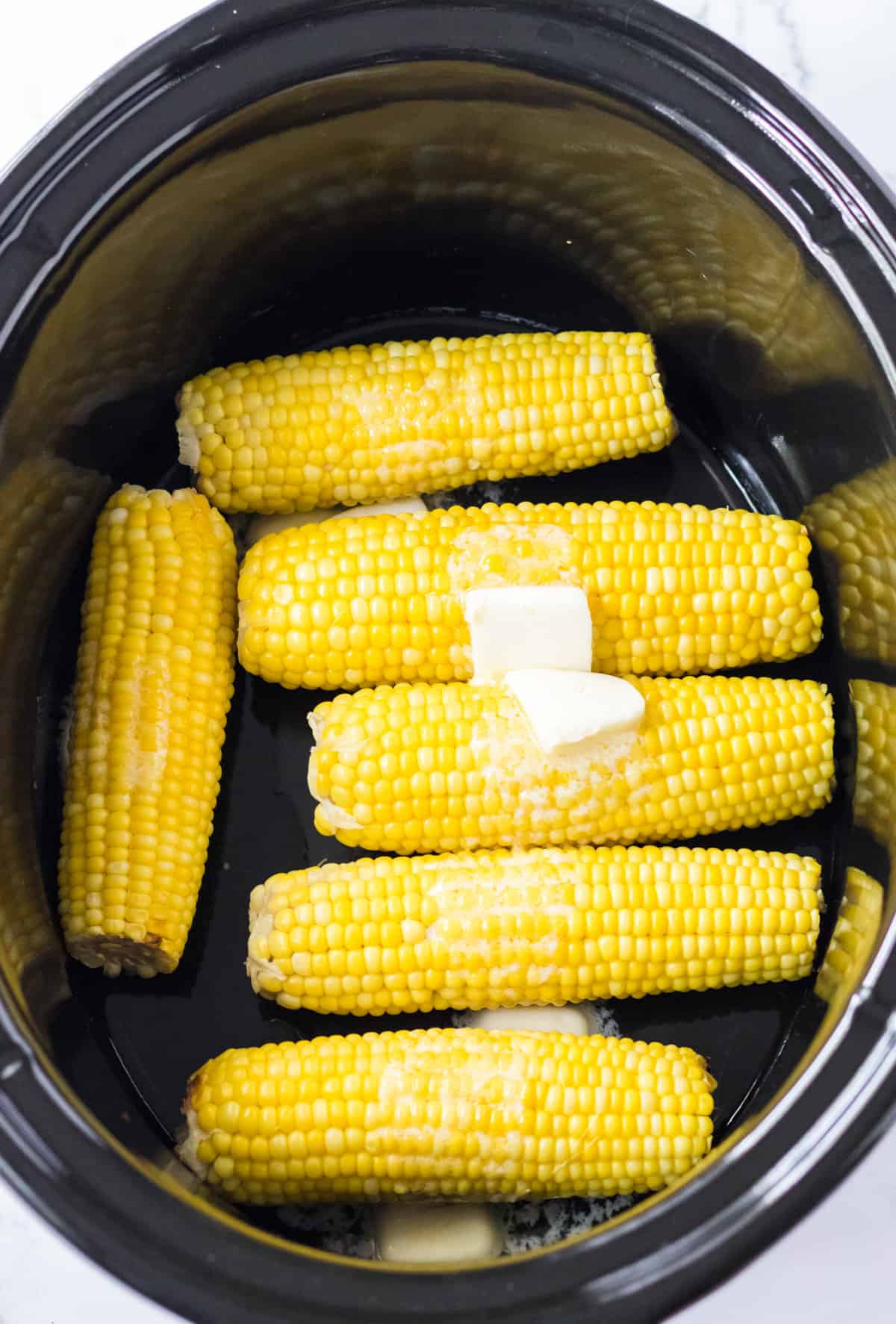Butter melting on top of corn in crock pot.