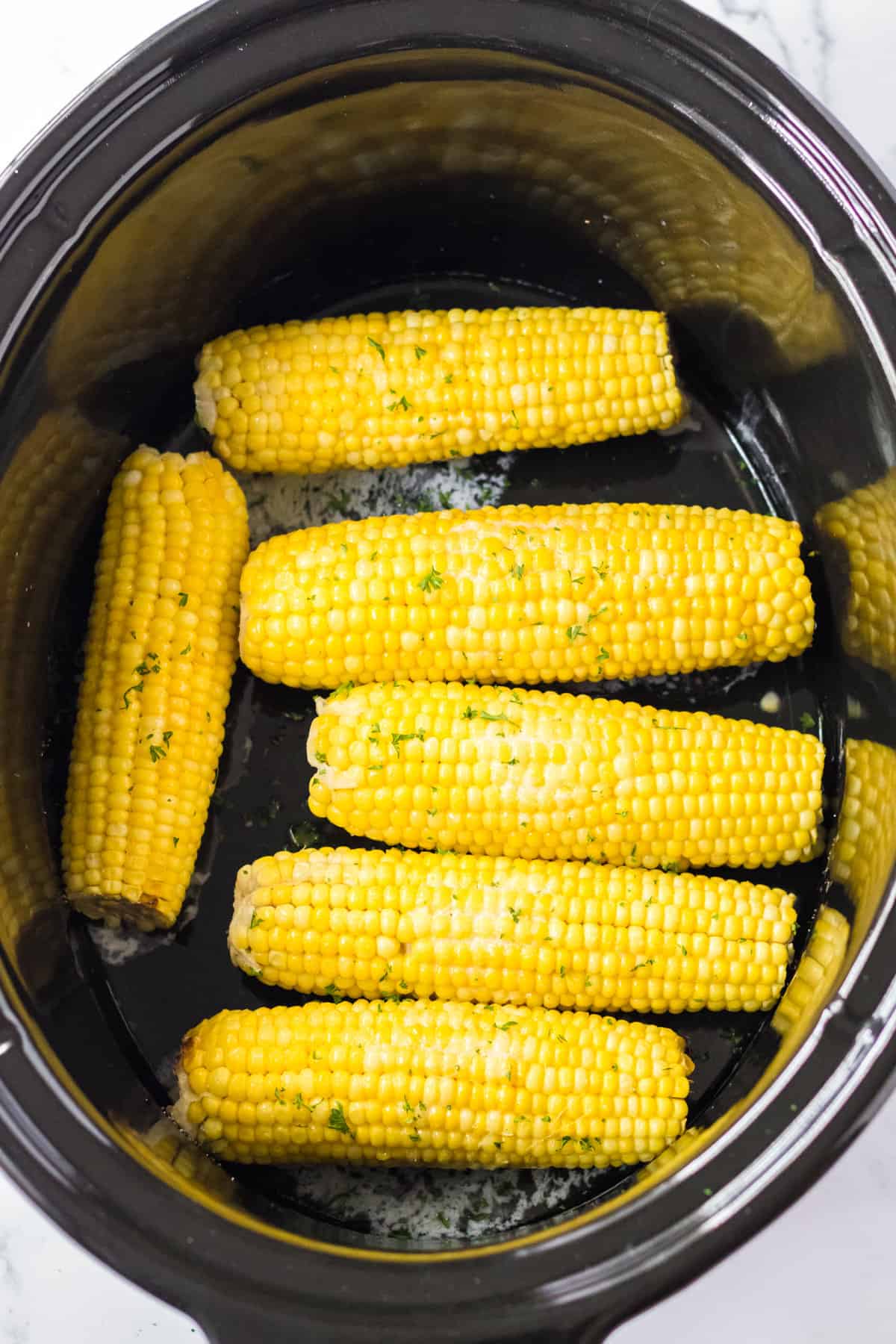 Slow cooker corn on the cob with butter and seasonings.