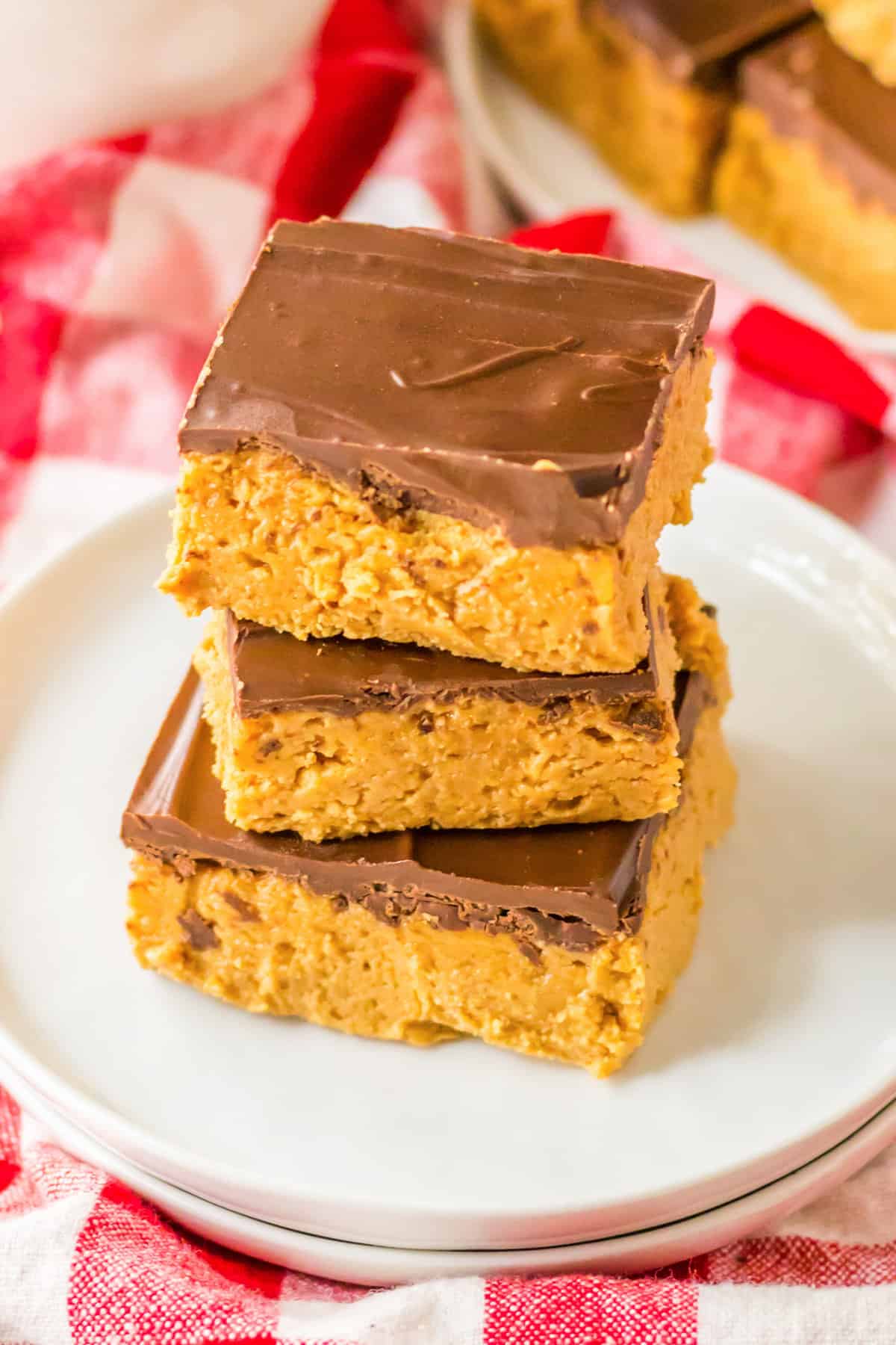 Three easy no bake peanut butter bars topped with a thin layer of chocolate.
