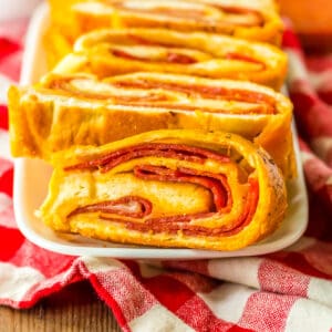 Pepperoni bread with frozen bread dough and mozzarella cheese sliced and on a white plate.