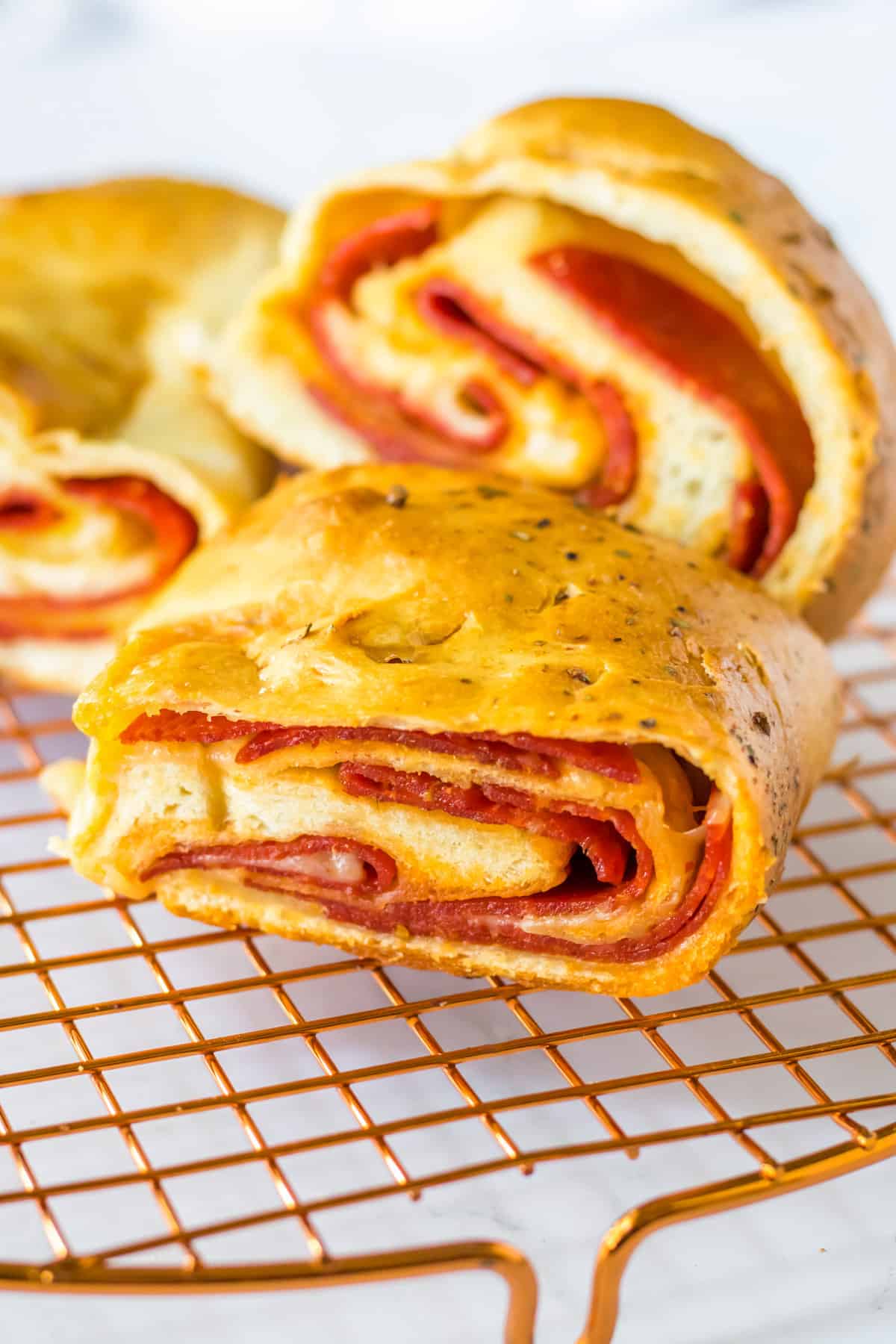 Slices of pepperoni and cheese bread on cooling rack.