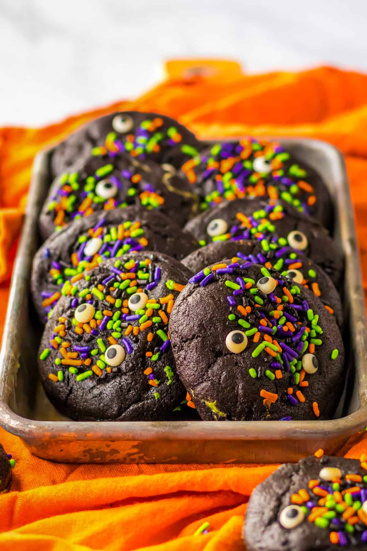 Tray of halloween cookies with sprinkles and candy eyes.