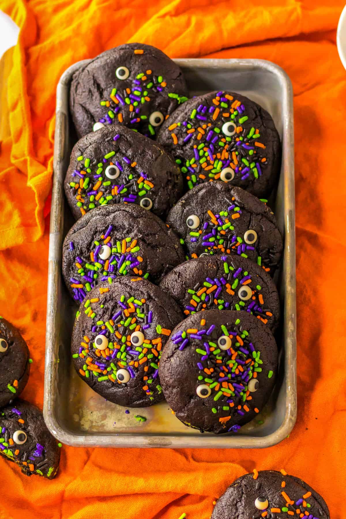 Dark Chocolate Halloween Cookies with Sprinkles on tray over orange linen.