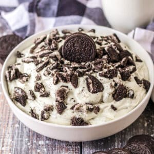 Oreo fluff dessert made with vanilla pudding, cool whip, oreo cookies, and milk.