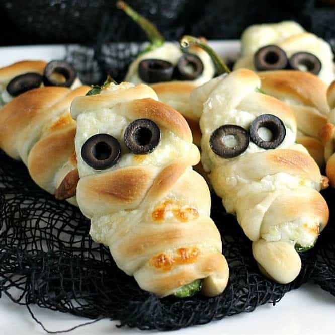 Jalapeno poppers wrapped in dough and decorated with olive eyes.