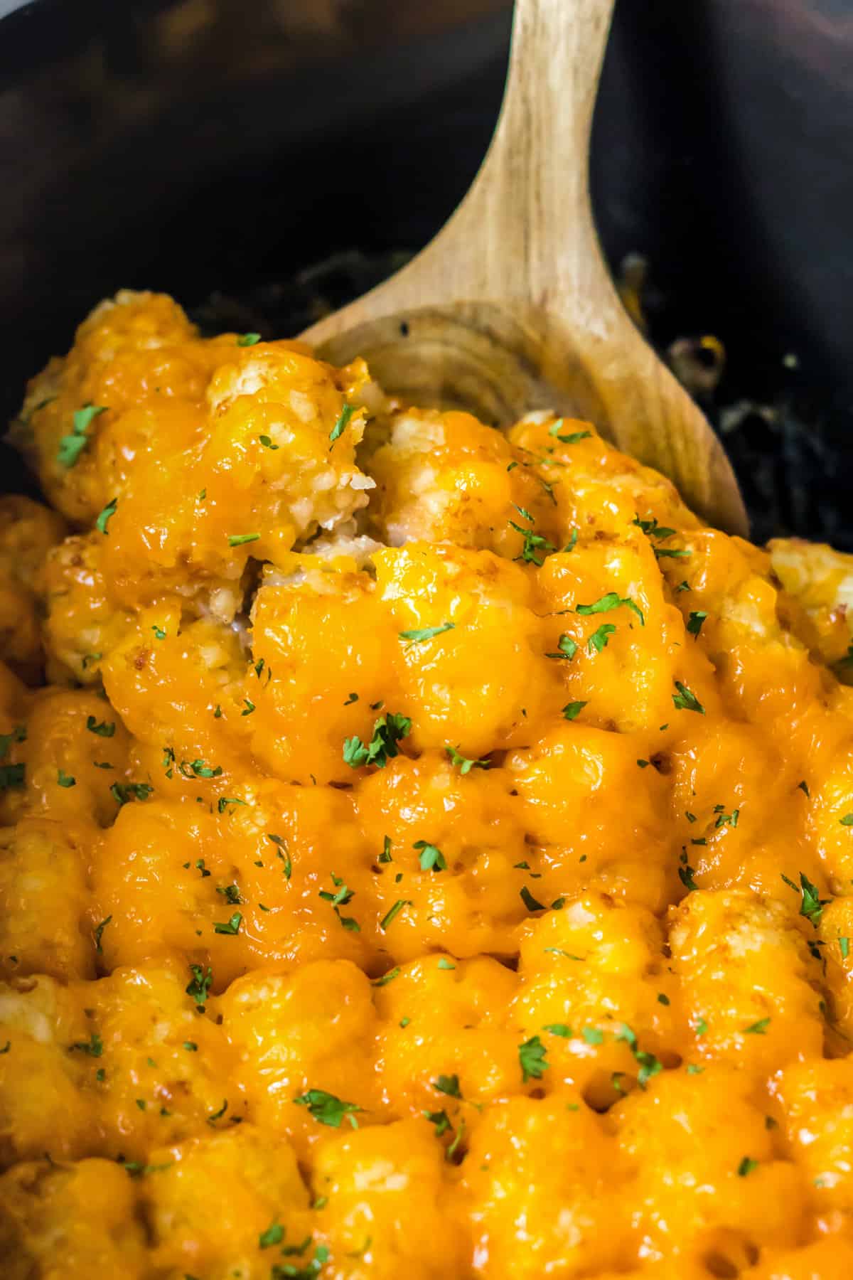 Wooden spoon in slow cooker tater tot casseorle.