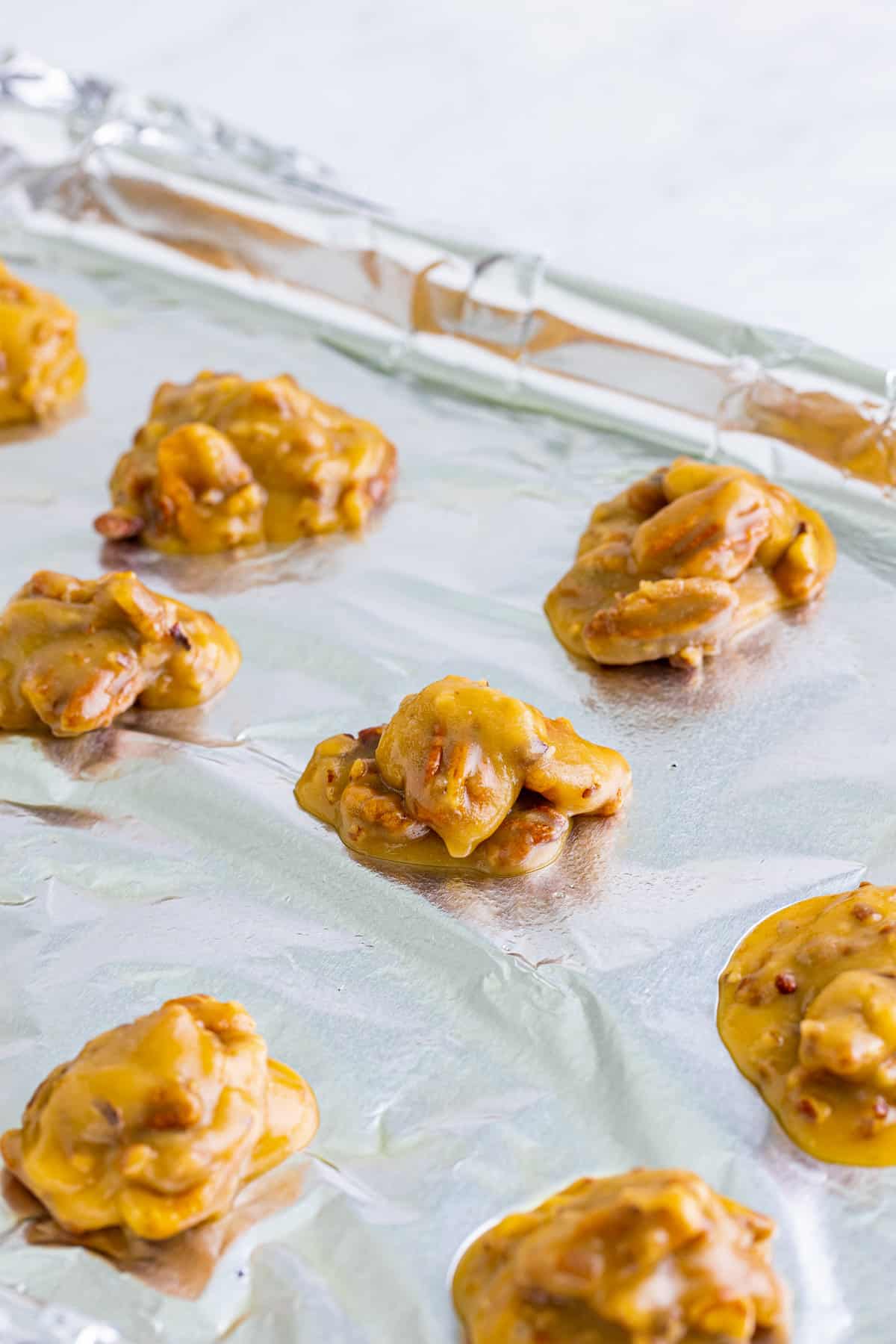 Praline Pecan candies on foil lined baking sheet.