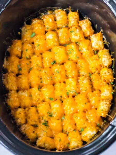 Slow cooker tater tot casserole with melted cheese and ground beef.