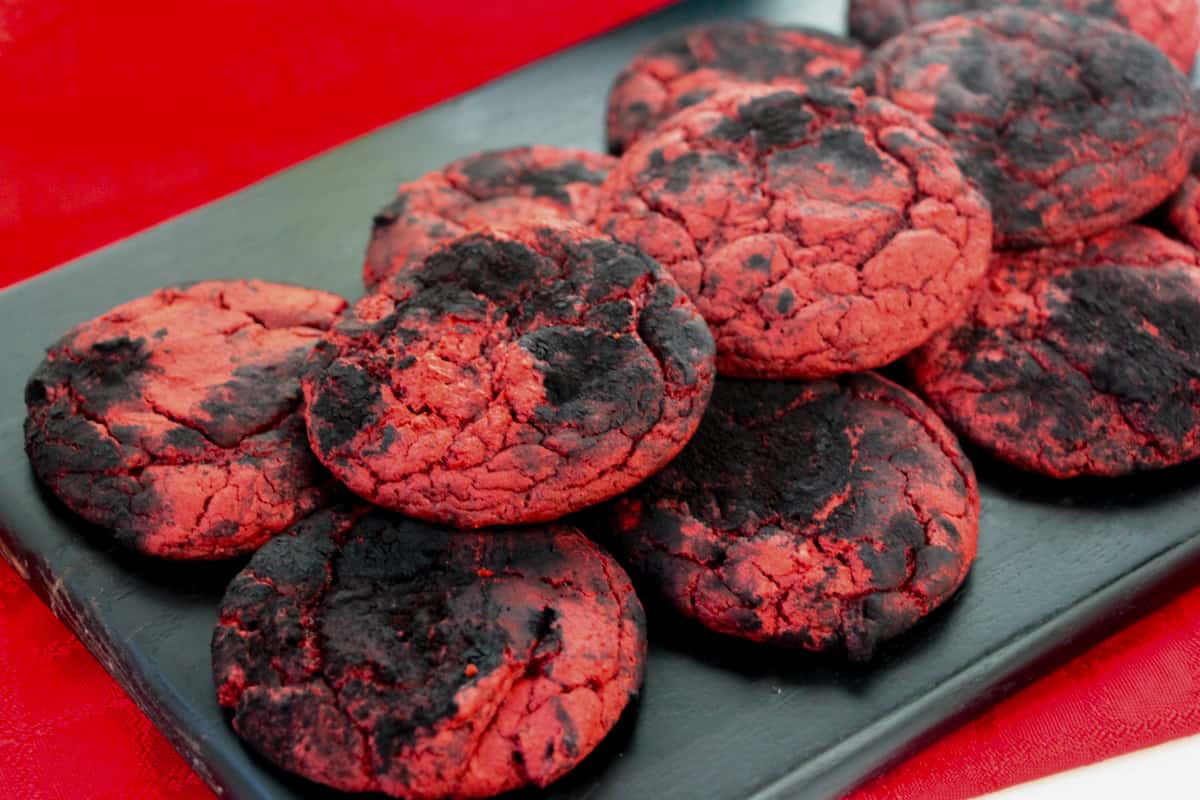 Brimstone cookies made with red velvet cake mix and black cocoa powder served on a dark wooden board.