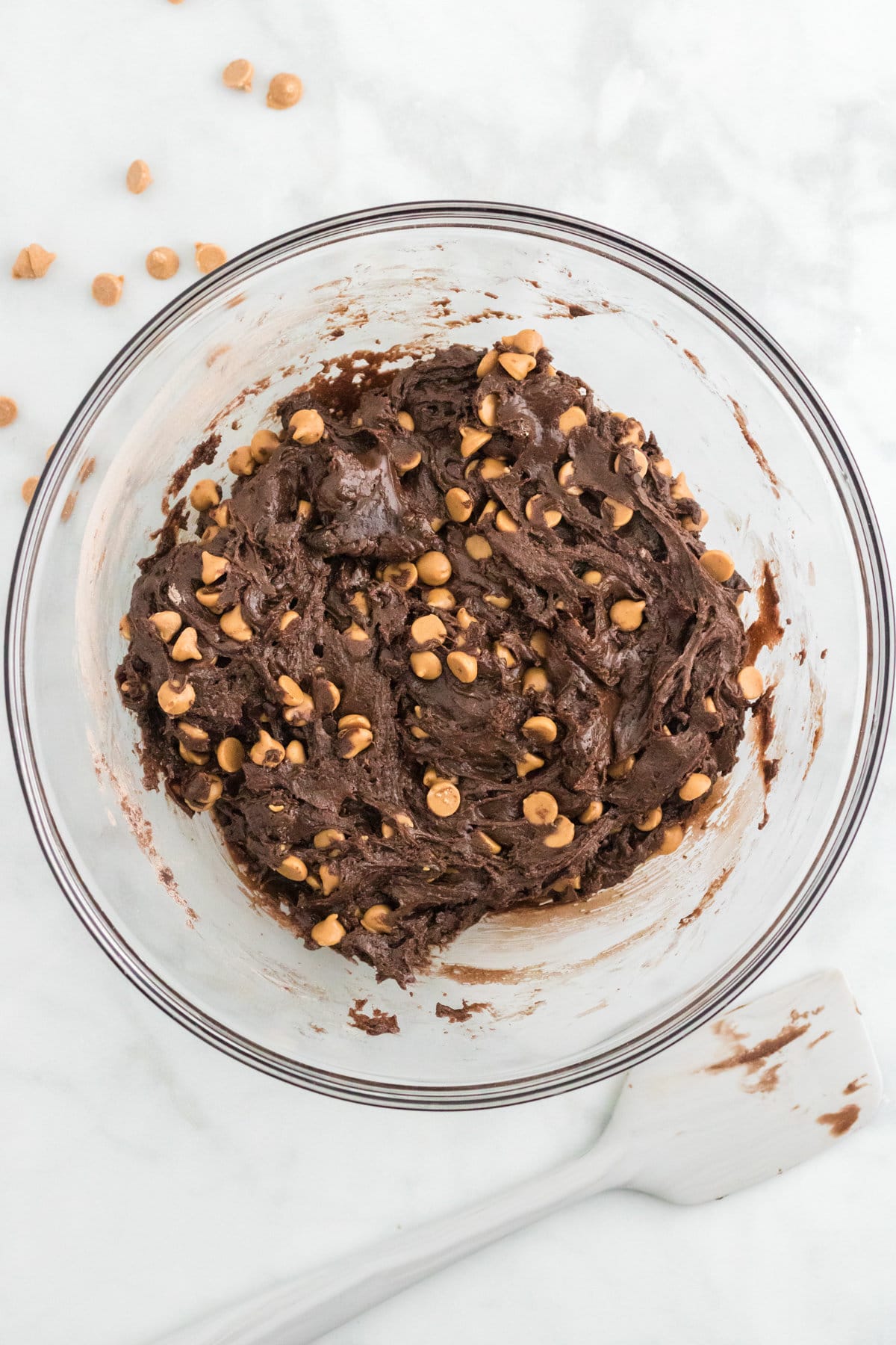 Chocolate peanut butter chip cookie dough in a glass mixing bowl.