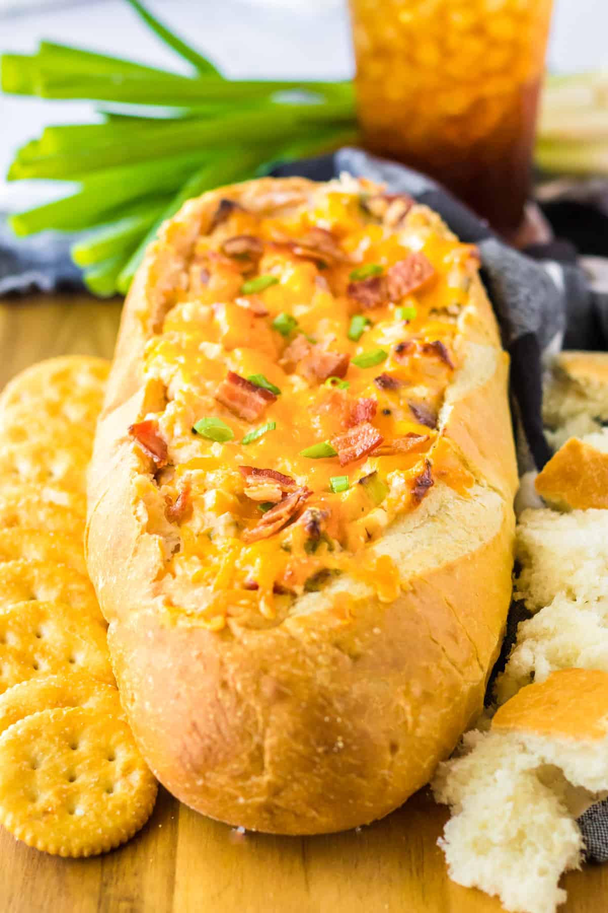 Mississippi sin dip with bacon baked in a french bread loaf and served with ritz crackers and bread pieces for dipping.