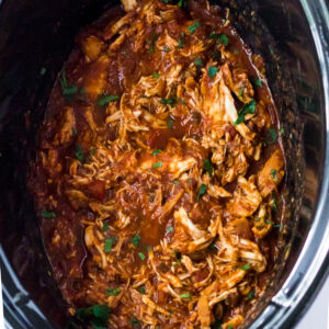 Slow cooker salsa chicken shredded in the bowl of a crockpot.