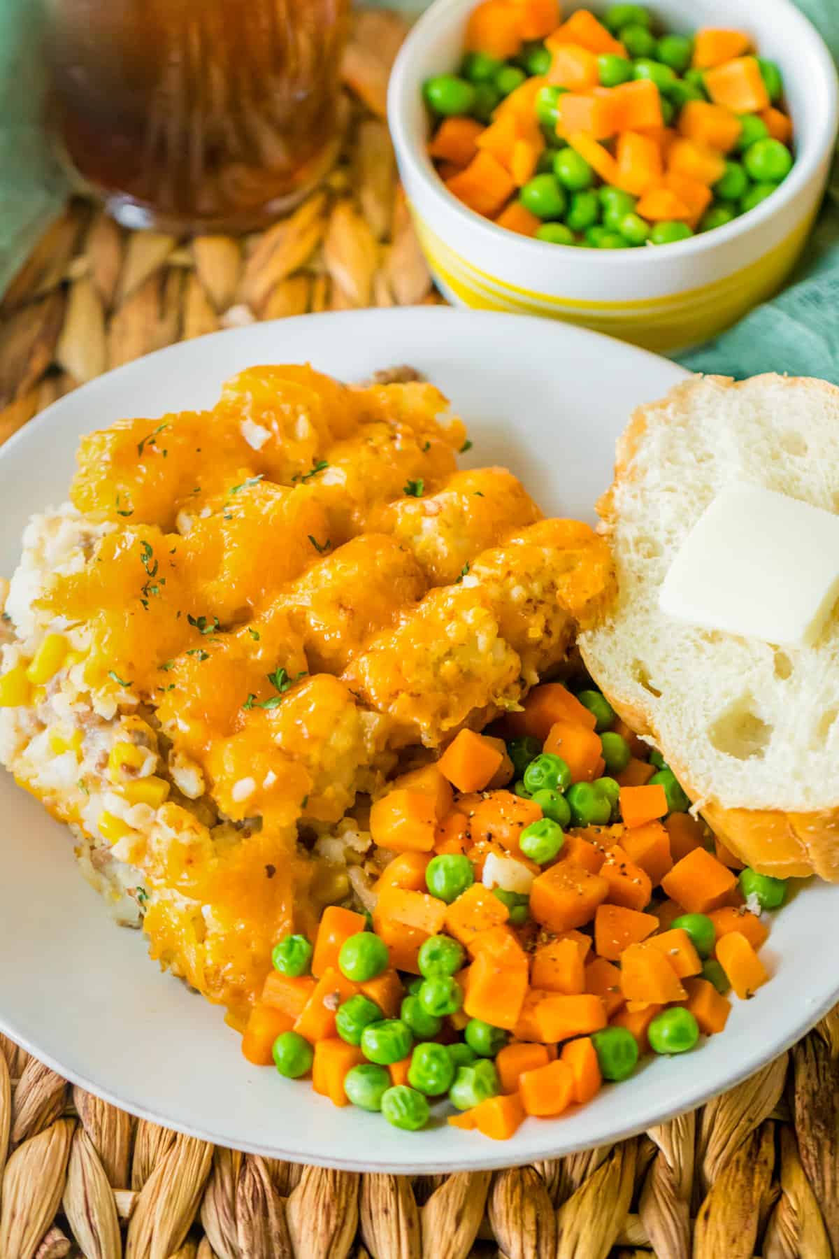 Ground Beef tater tot casserole served with peas, carrots, and buttered bread.