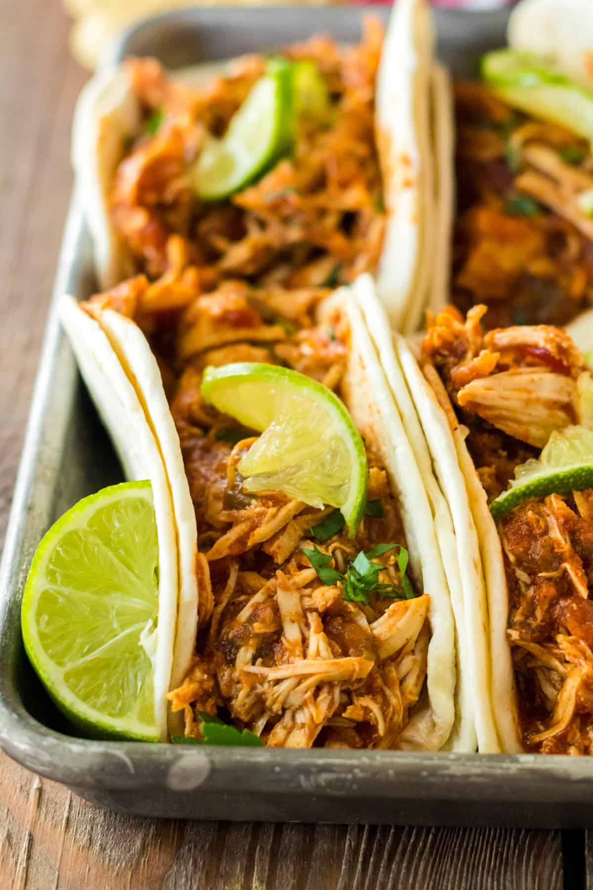 Slow cooker shredded chicken tacos with salsa and taco seasoning.
