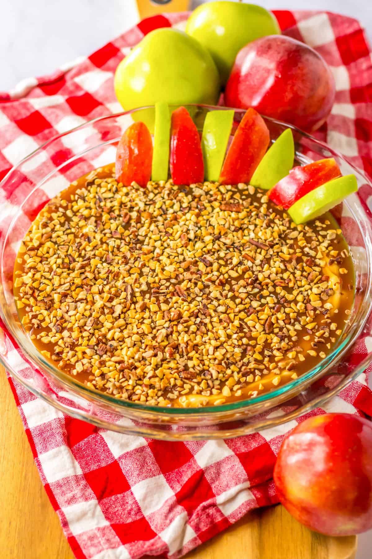 Caramel and cream cheese dip for apples served in a 9 inch round glass pie pan.