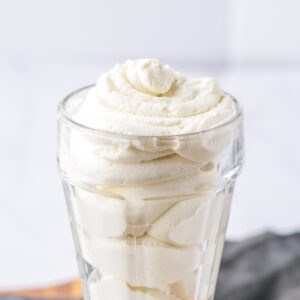 Light and creamy homemade stabilized whipped cream in a glass.
