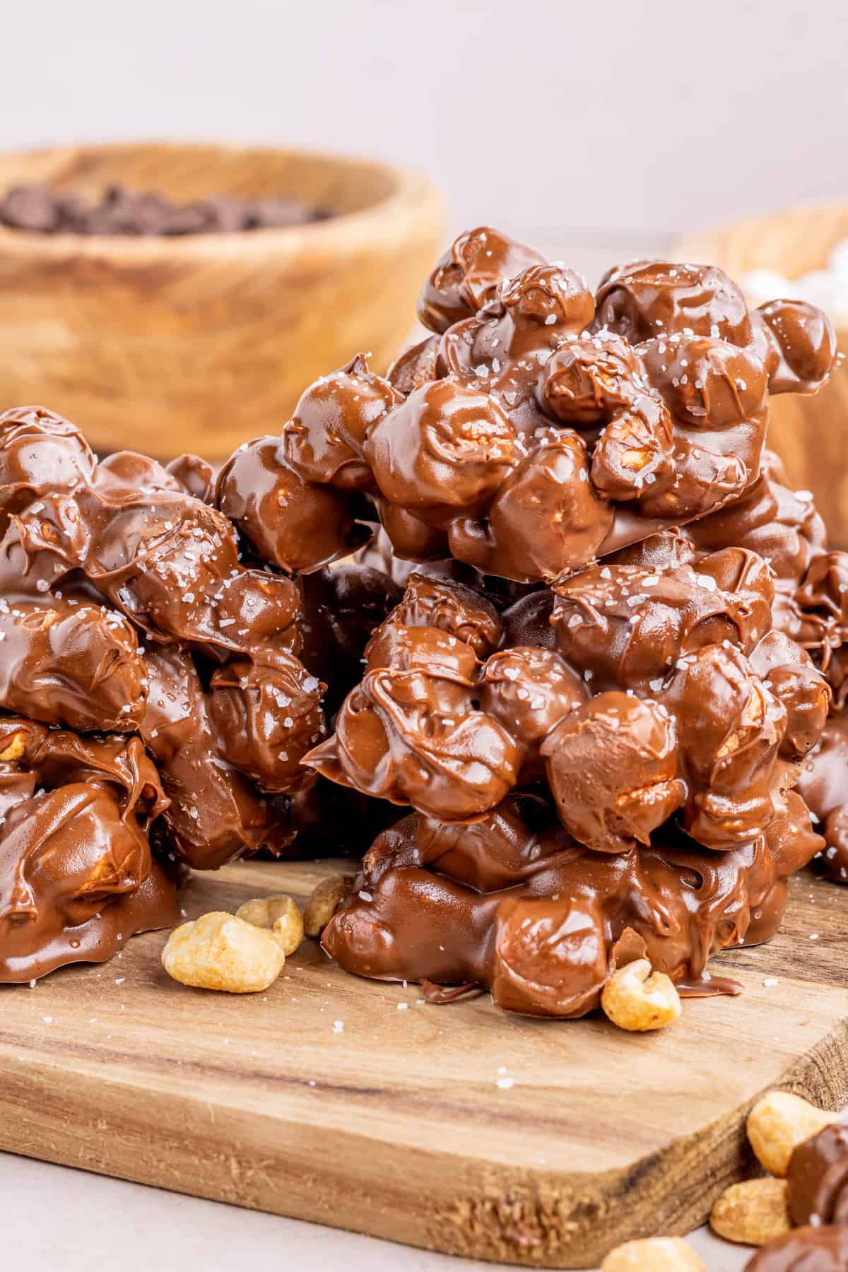 Chocolate peanut and marshmallow clusters on wooden board.