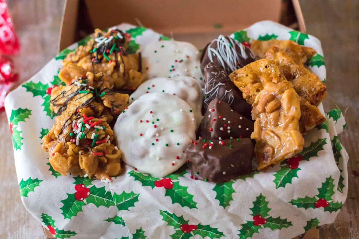 Variety of homemade Christmas candies in gift box lined with holiday tissue paper.