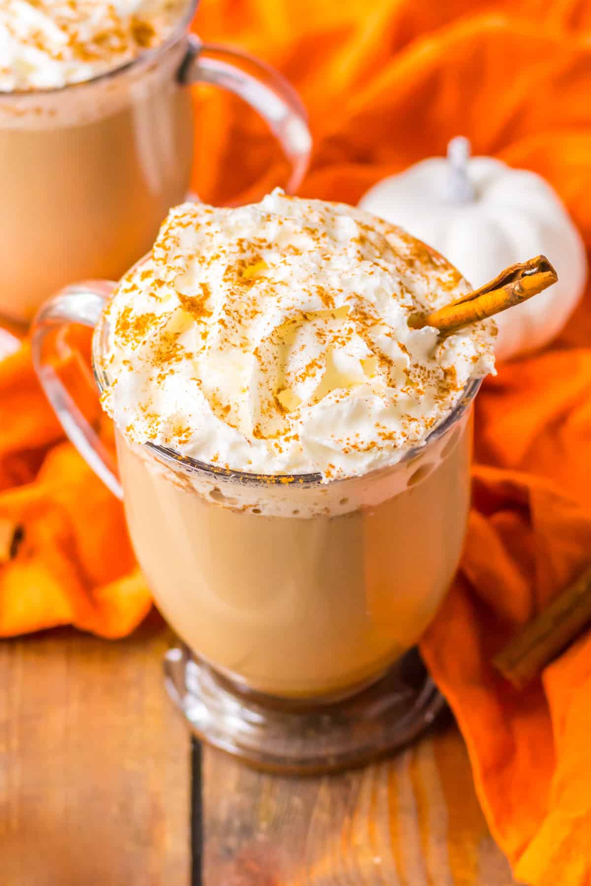 Crockpot Pumpkin Spice Latte in a glass mug topped with whipped cream, cinnamon, and a cinnamon stick.