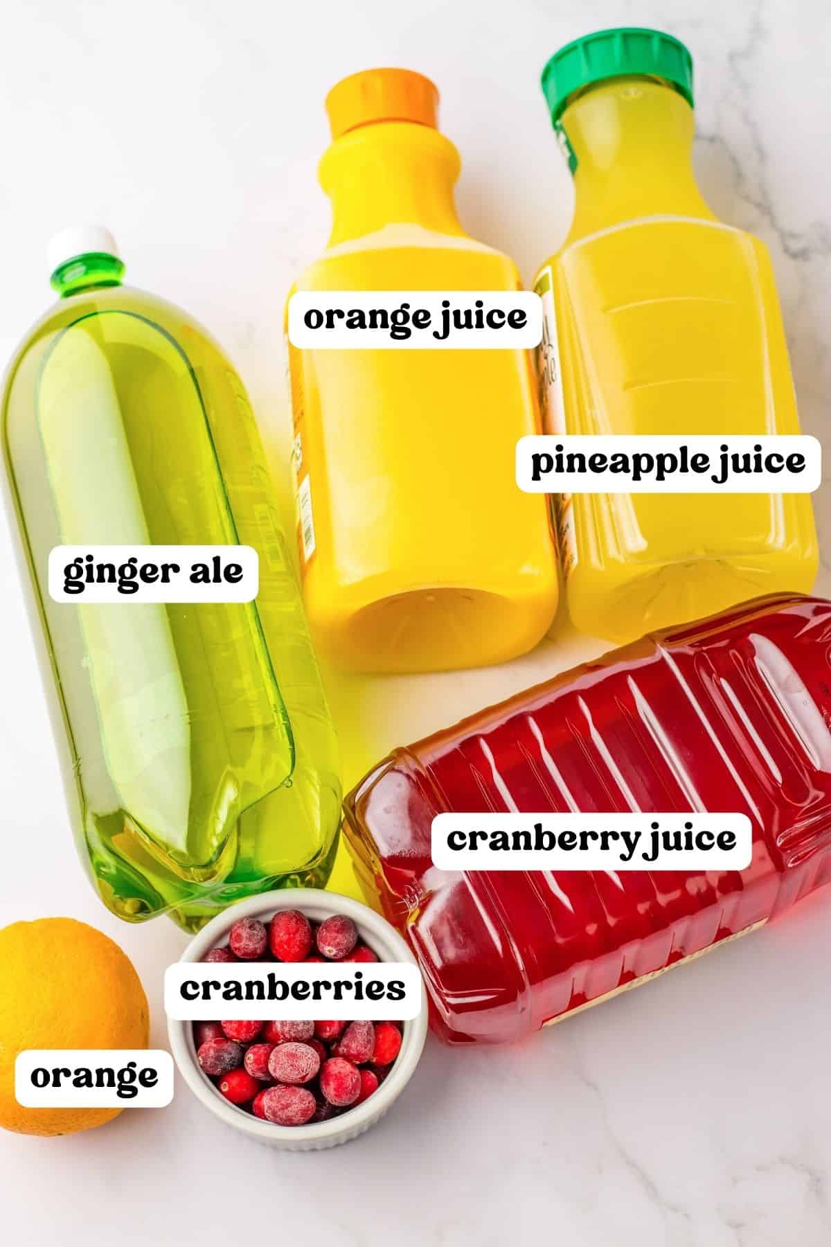 Bottles of orange juice, pineapple juice, cranberry juice, and ginger ale along with fresh cranberries and an orange.