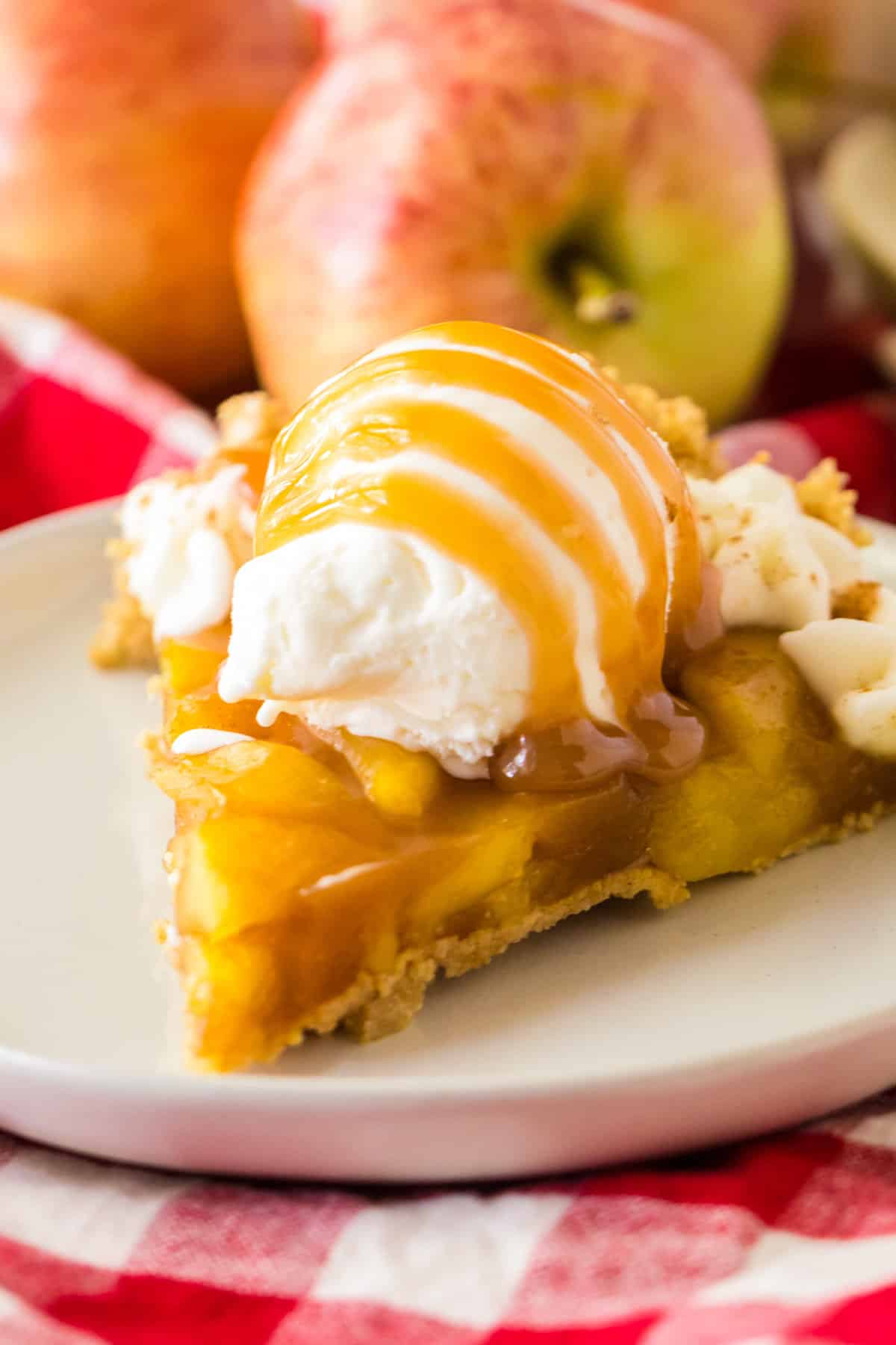 No bake apple pie with a grapham cracker crust topped with a scoop of vanilla ice cream and caramel sauce.