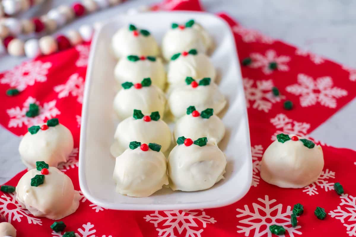 Snickerdoodle Truffles on white serving platter surrounded by holiday decor.