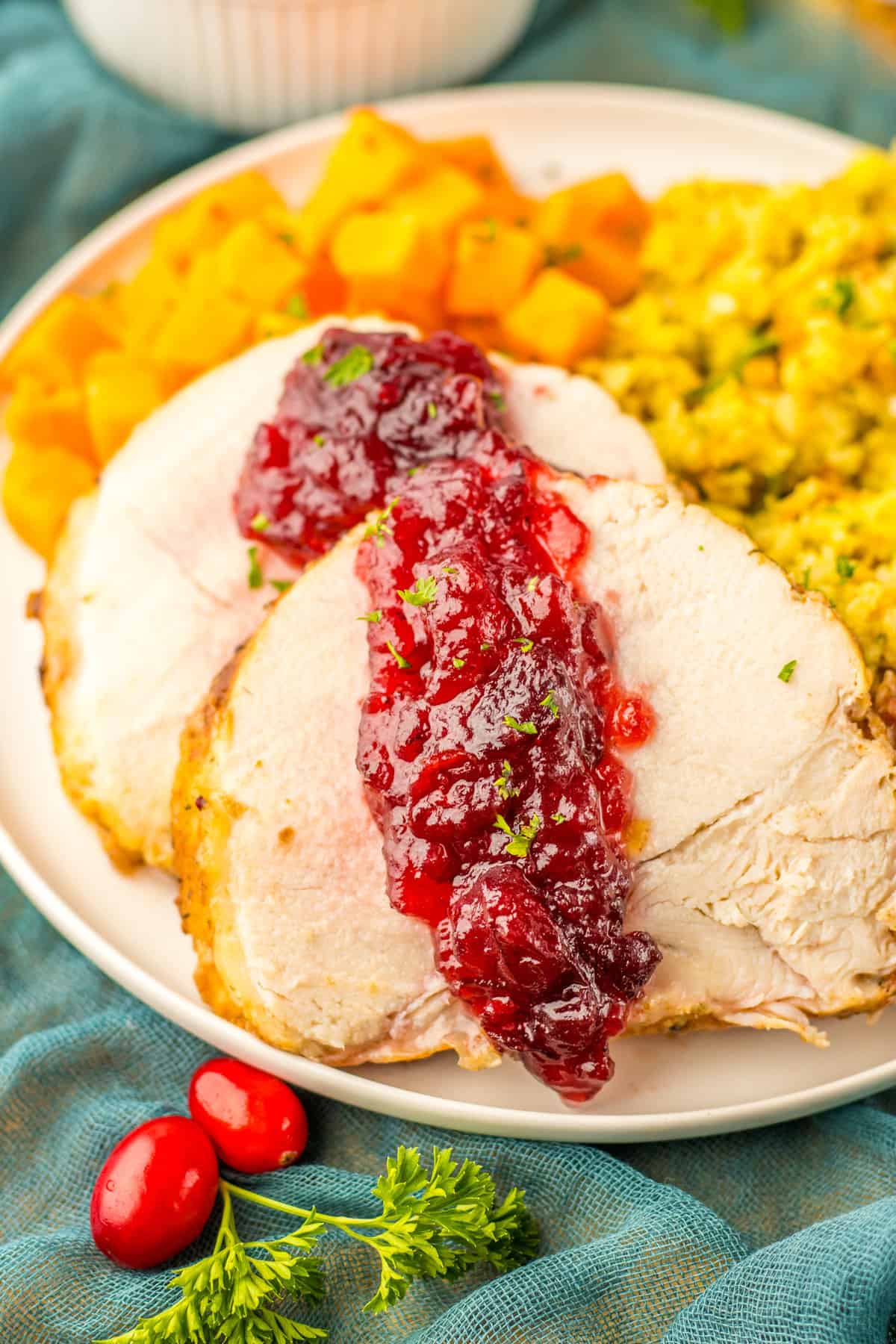 Slow cooked boneless turkey breast topped with cranberry sauce and served with stuffing and sweet potatoes.