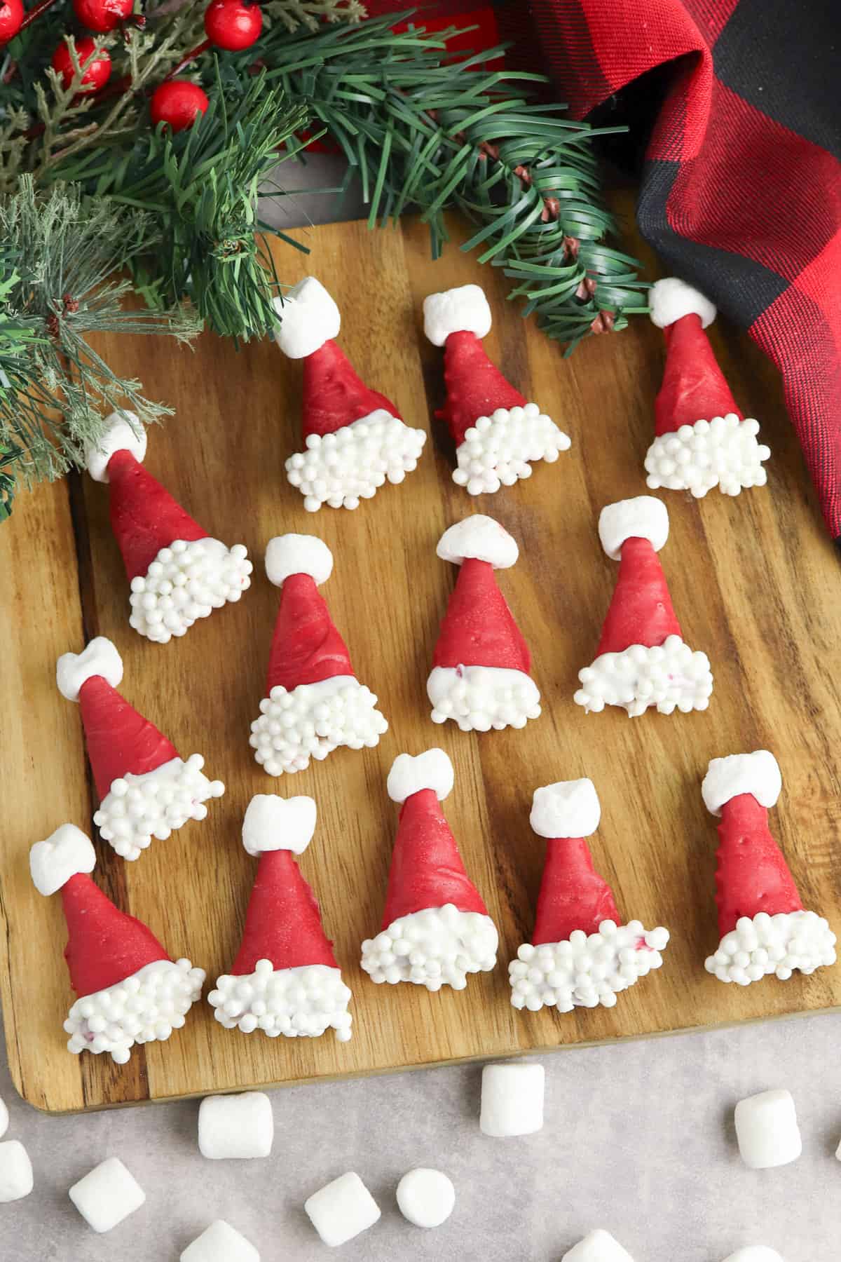 Easy no-bake Santa hat Bugles, bugle corn snacks dipped in red candy melts and decorated with white sprinkles and mini mashmallows to look like cute little santa hats!