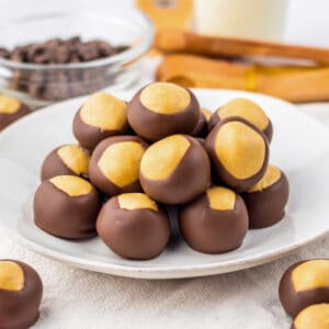 Peanut butter buckeye balls stacked on a white plate.