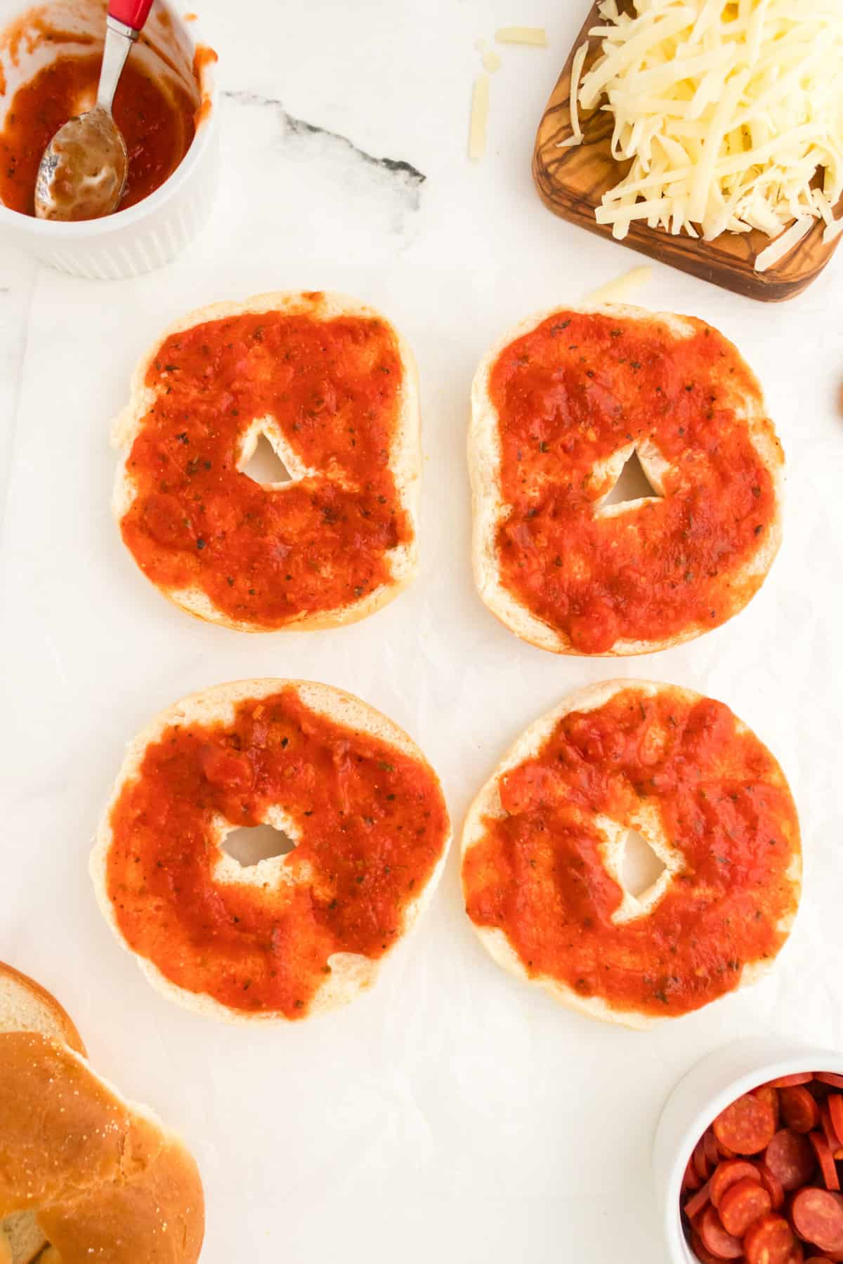 Bagel halves with 1-2 Tablespoons of sauce spread on them.