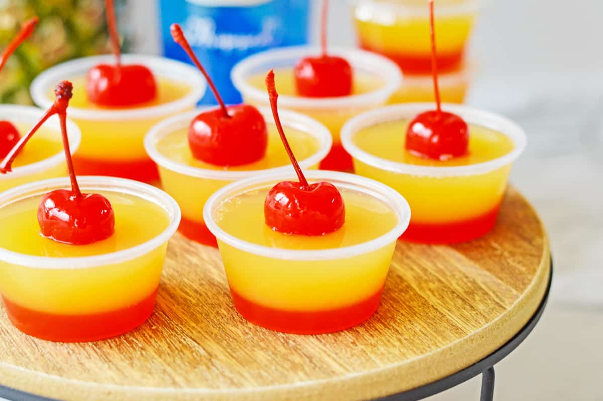 Upside down cake flavored gelatin shots topped with maraschino cherries.