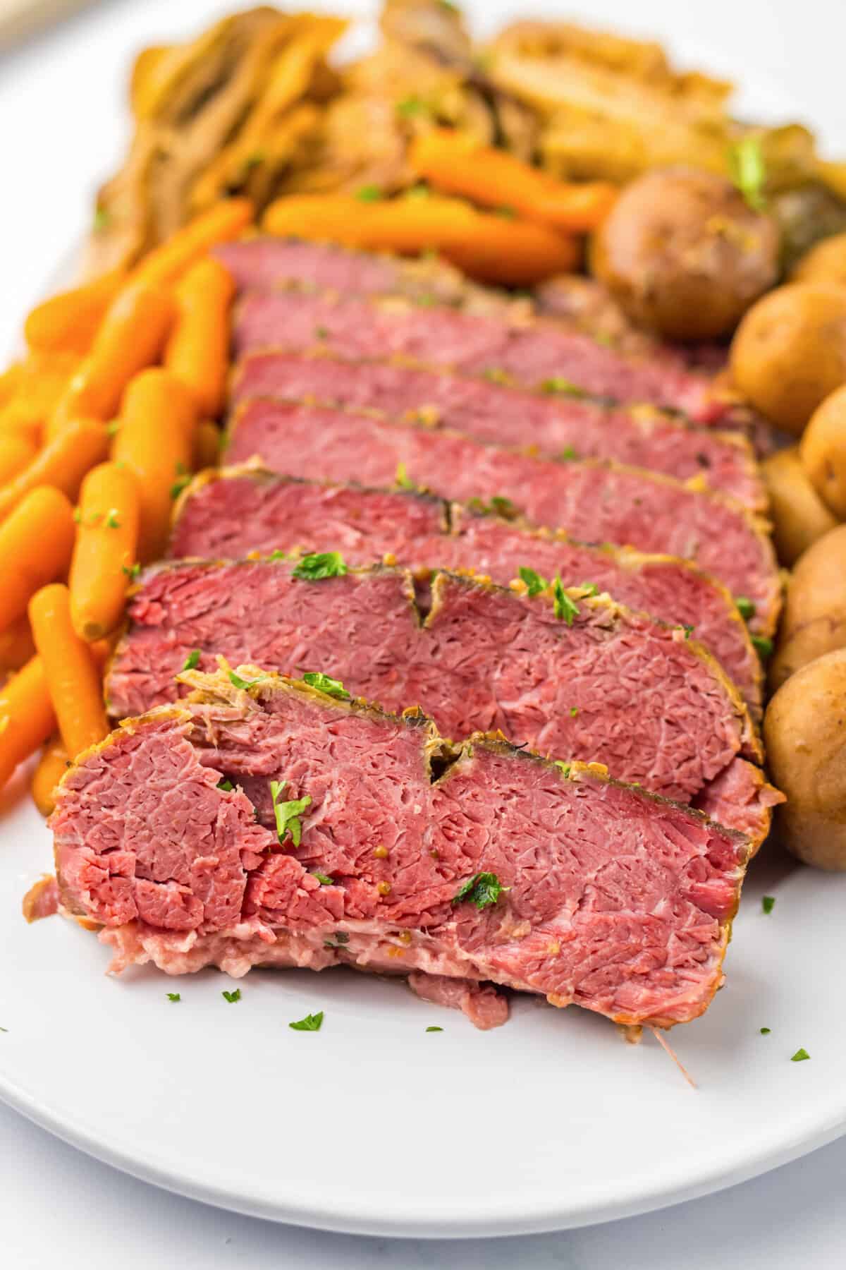 Sliced corned beef with cabbage, carrots and potatoes.