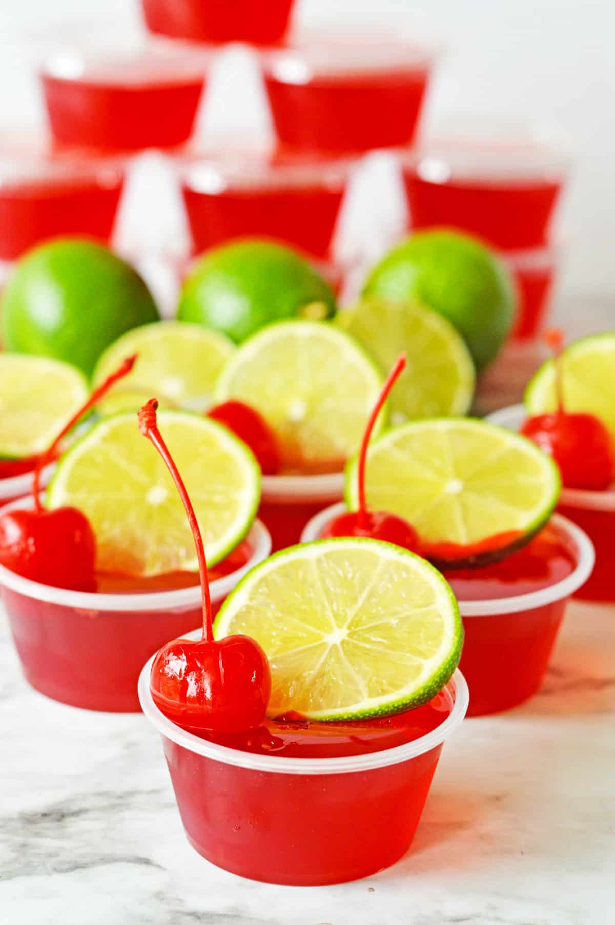 Cherry limeade jello shots topped with fresh lime wheel and maraschino cherry.