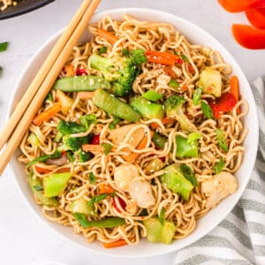 Ramen Stir-fry with vegetables in a white bowl with chopsticks.