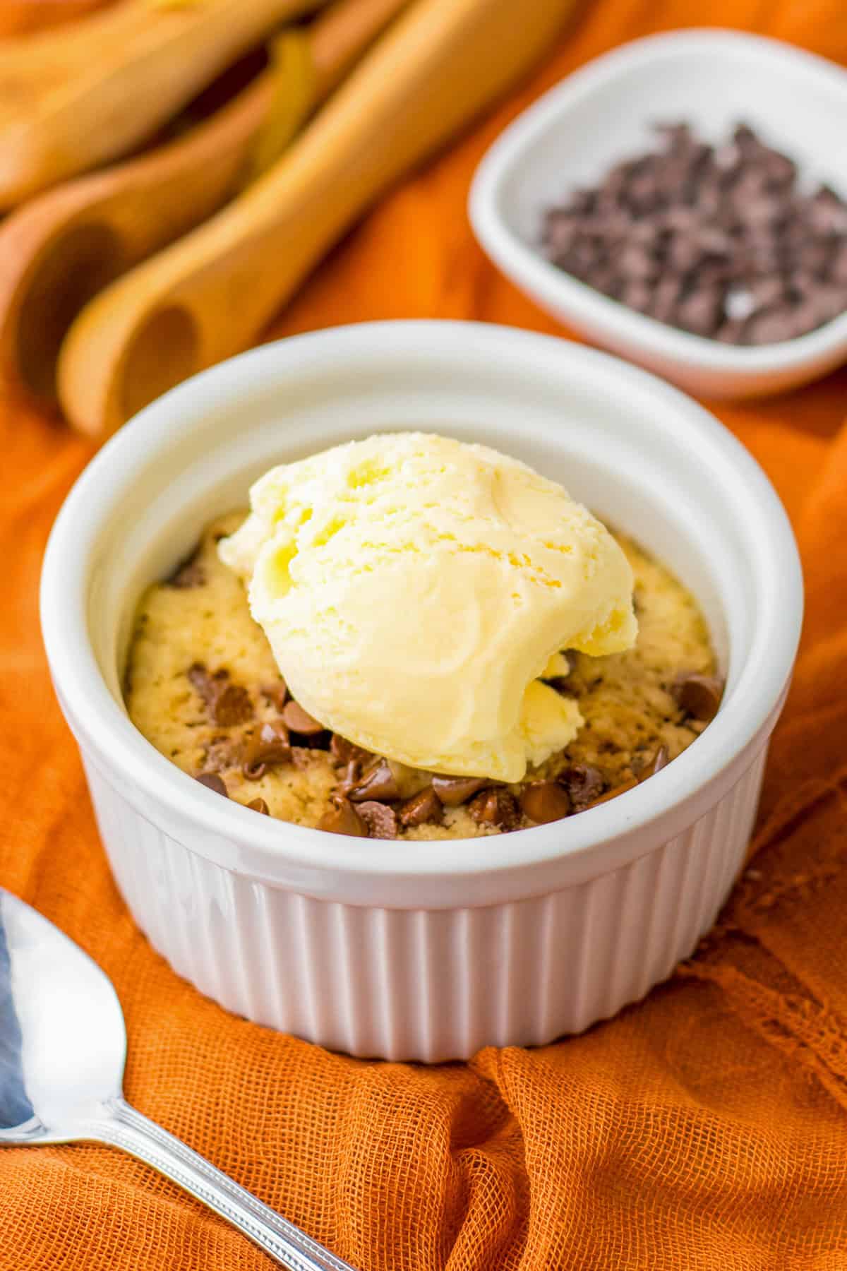 Microwave Chocolate Chip Cookie in a ramekin topped with vanilla ice cream.