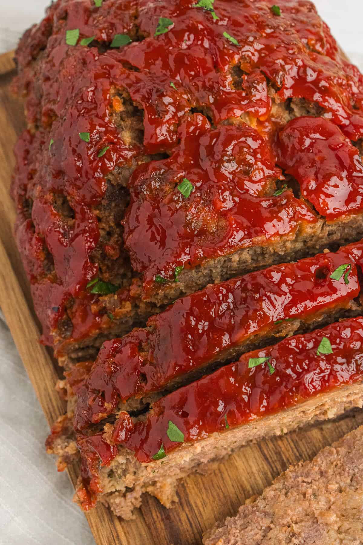 Meatloaf on cutting board, half has been sliced.