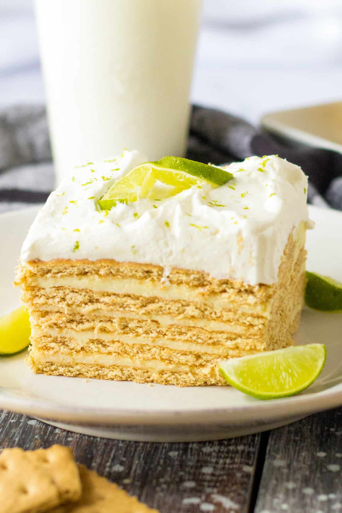 Key lime icebox cake with layers of graham crackers and key lime custard topped with homemade whipped cream and a lime garnish.