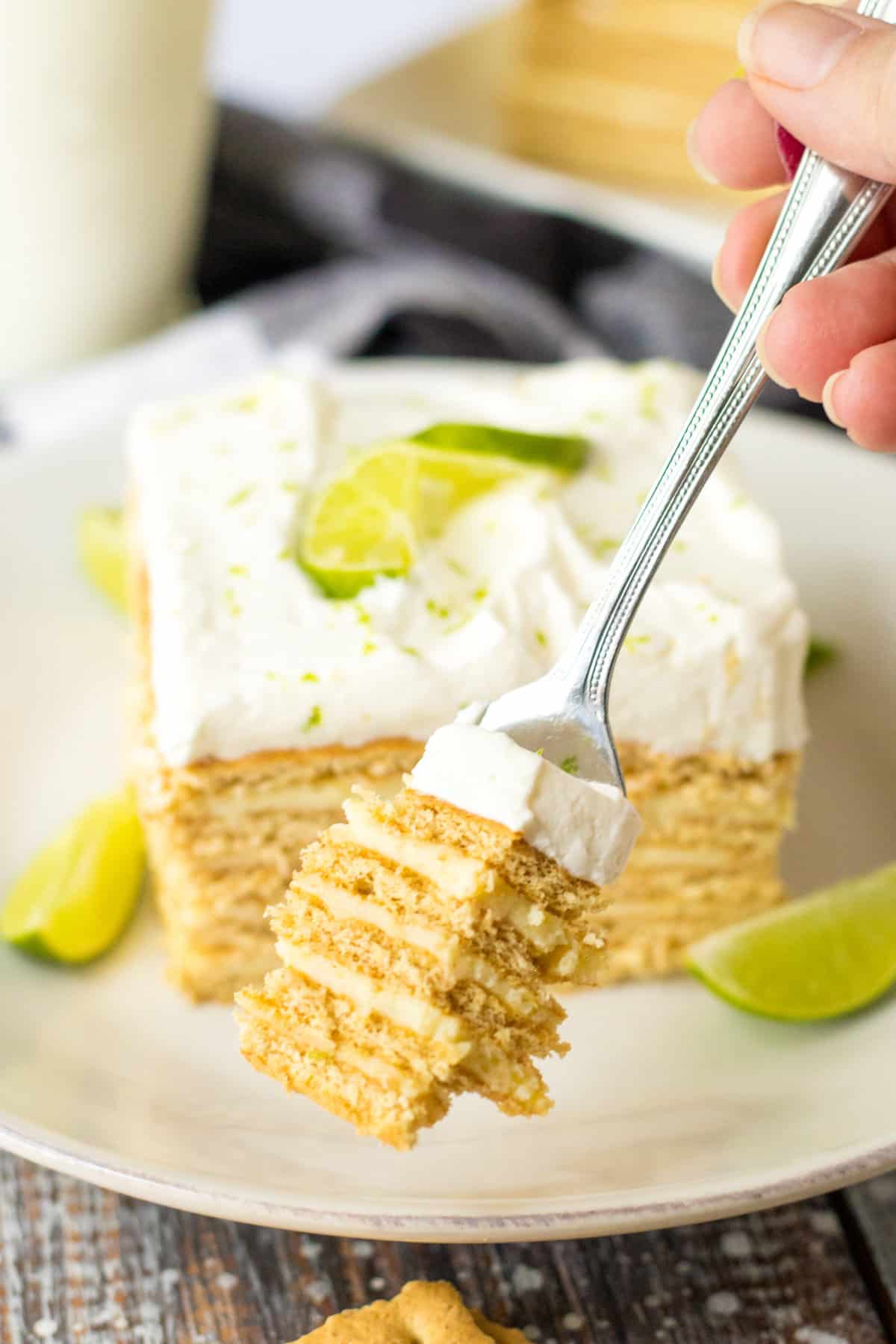 Fork removing a piece from a slice of no bake key lime cake.