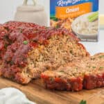 Lipton Onion Soup Mix Meatloaf with ketchup glaze and box of Lipton soup mix packets.