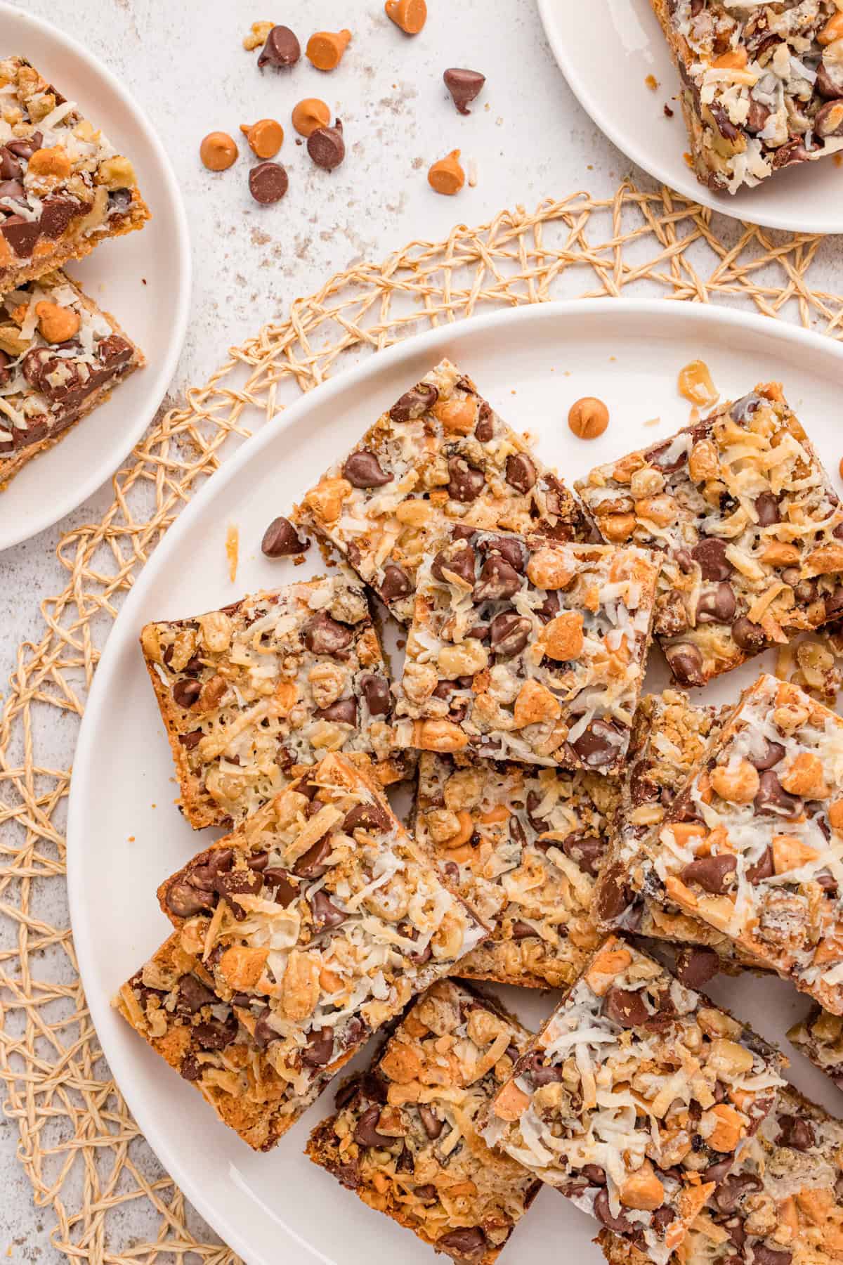 Homemade 7 layer magic cookie bars piled on a large platter for serving.