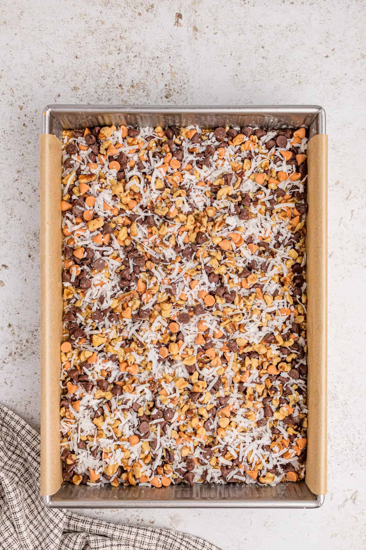 Chocolate chips, butterscotch chips, coconut, and chopped nuts added over graham cracker base.