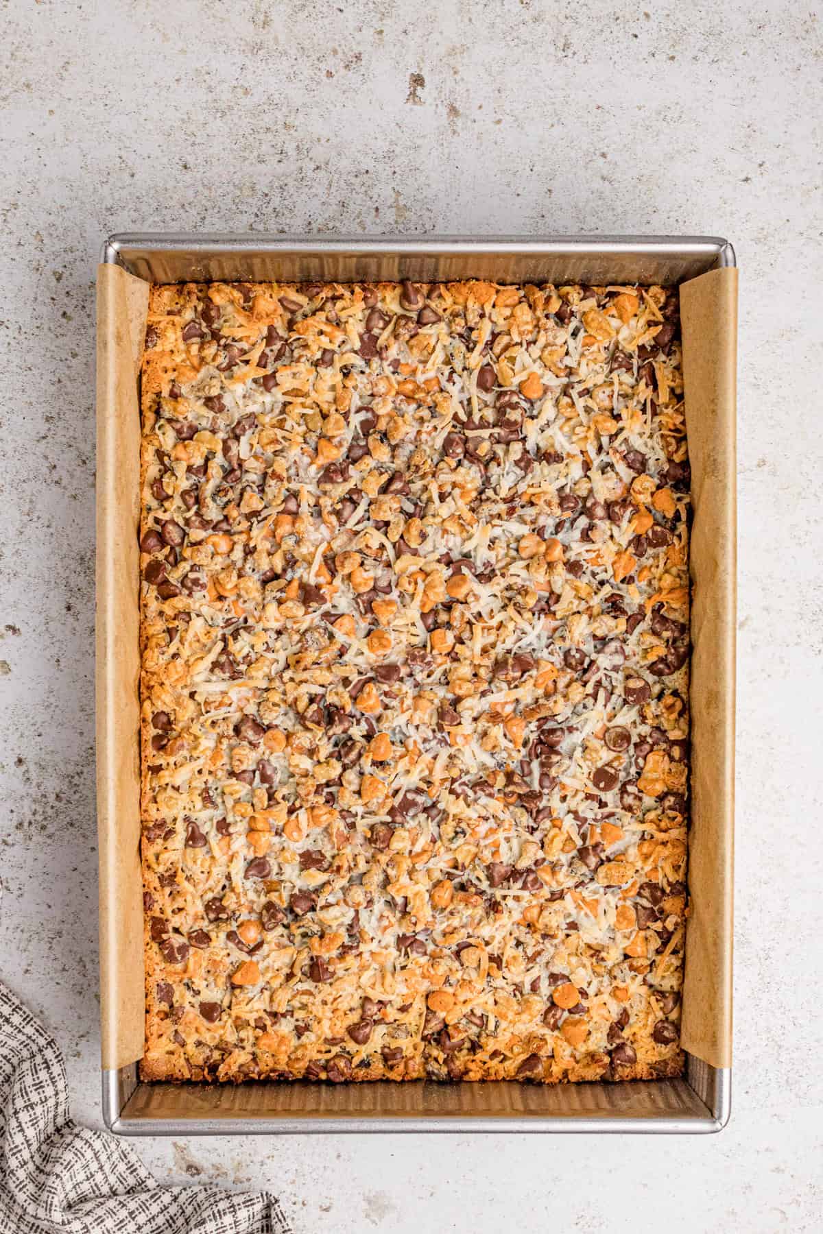 Baked 7 layer cookie bars with golden edges and toasted coconut. The sweetened condensed milk has been absorbed into the bars.