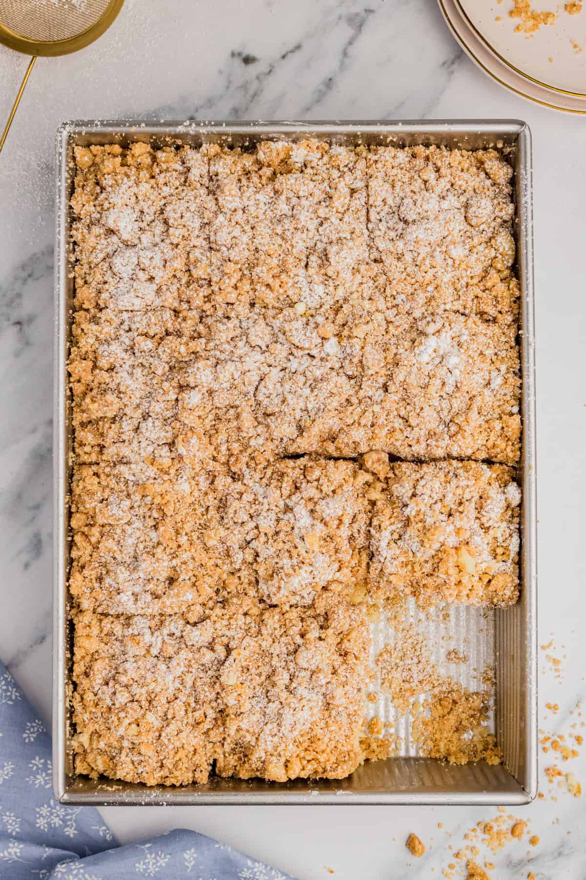 New York style crumb cake dusted with powdered sugar and sliced into squares.