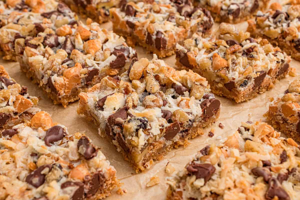 7 layer magic cookie bar squares on parchment paper.