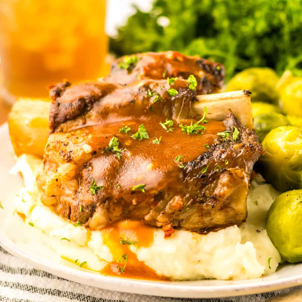 Slow Cooker Short Ribs served over mashed potatoes and topped with brown gravy.